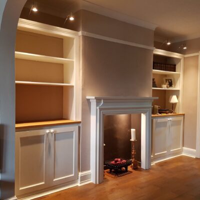 Bespoke wood alcove cupboard built around a chimney breast