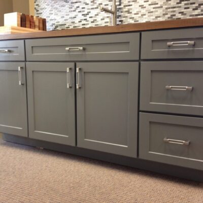 Grey painted shaker cupboard doors on fitted kitchen units with wood worktop