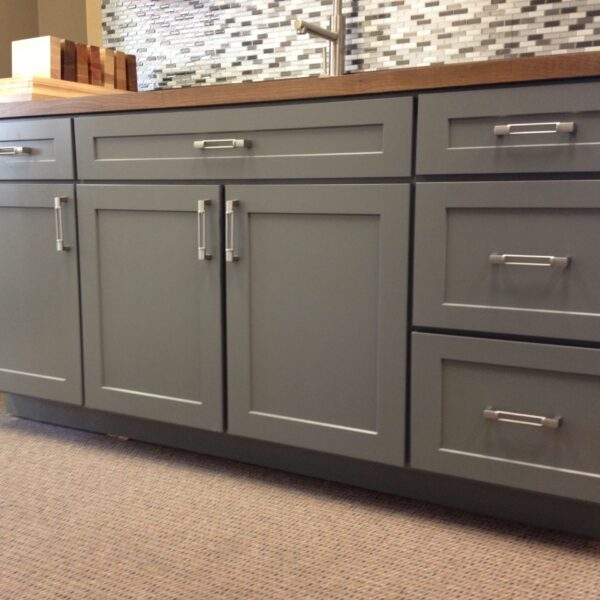 Grey painted shaker cupboard doors on fitted kitchen units with wood worktop