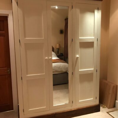 Pine shaker wardrobe doors open in a bedroom