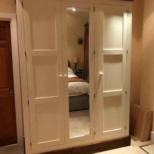 Pine shaker wardrobe doors open in a bedroom