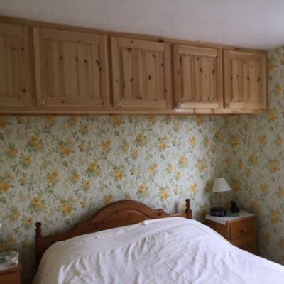 Raised and fielded pine door in a bedroom with floral wallpaper